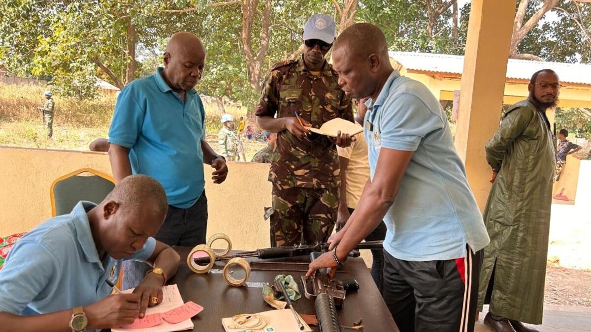 Des Casques bleus et des membres de la communauté se tiennent autour d'une table, travaillant