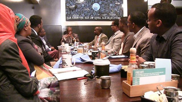 A group of men and women sit around a table