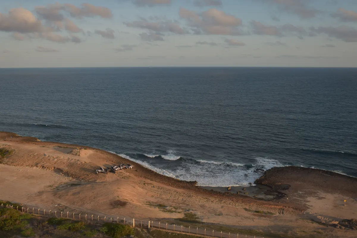 A photo of a beach in Somalia where some cars and people can be seen