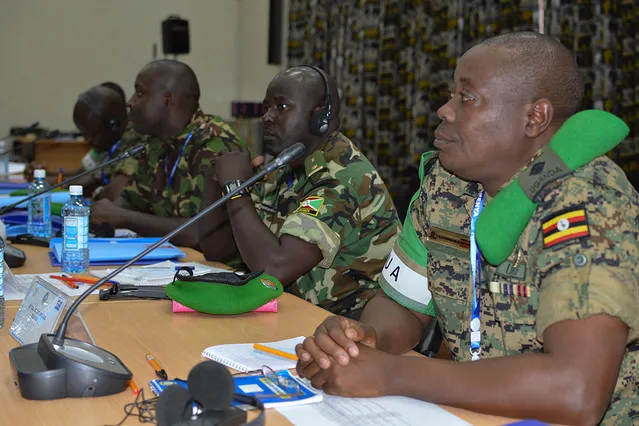 Men in uniform sit at a table in front of microphones